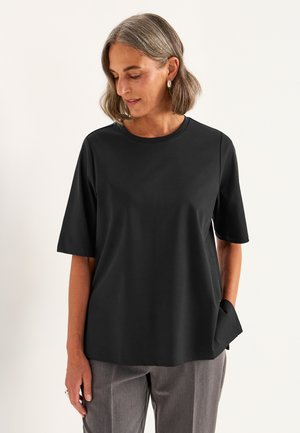 Zwart T-shirt met korte mouwen en een ronde halslijn, gemaakt van een soepele stof, met een relaxte pasvorm en een subtiele zakdetail aan één kant.