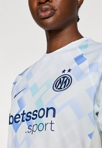 Gaiši zils džersija ar ģeometrisku rakstu; satur Nike logo, "betsson.sport" tumši zilā krāsā un apaļu komandas nozīmīti ar zvaigznēm.