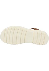 Helle beigefarbene Gummisohle mit strukturierten Grip-Mustern und einer sanft erhöhten Kante. Flexibles Design, ideal für Komfort und Langlebigkeit.