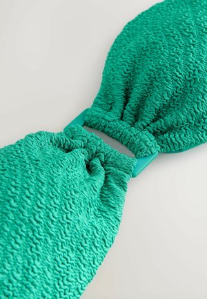 Turkiozi tekstūruotas plaukų aksesuaras su surinkta medžiaga ir lygiu stačiakampiu užsegimu. Minkšta, surinkta medžiaga suteikia tamprumą ir lankstumą.