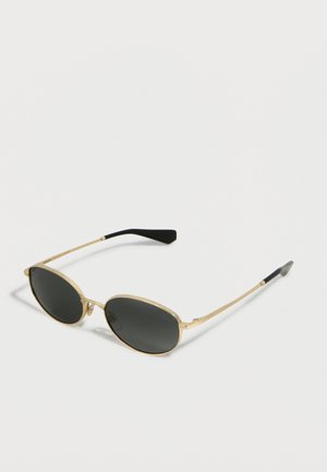 Slim gold-framed oval sunglasses with dark lenses and black earpieces resting on a light surface.