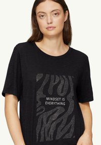 Schwarzes T-Shirt mit strukturiertem Design und abstrakten Linien sowie dem Text „MINDSET IST ALLES“ in Weiß, Rundhalsausschnitt, kurze Ärmel.