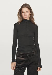 Black long-sleeve turtleneck made from a lightweight fabric, featuring a fitted design and a center seam down the front.