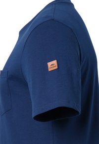 T-shirt a maniche corte di colore blu navy realizzato in cotone, con taschino sul petto e un'etichetta in pelle beige con la scritta "Forsberg" sulla manica.