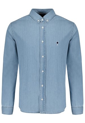Camisa de mezclilla azul claro con mangas largas, cuello abotonado y seis botones en la parte delantera. Presenta un pequeño logo bordado de un árbol en el lado izquierdo del pecho.