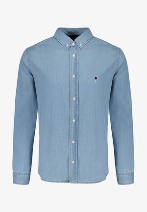 Camisa de mezclilla azul claro con mangas largas, cuello abotonado y seis botones en la parte delantera. Presenta un pequeño logo bordado de un árbol en el lado izquierdo del pecho.