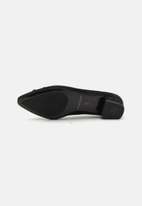 Black suede pointed-toe shoe with a sleek rubber sole, smooth finish, and a minimal logo on the heel. Elegant and streamlined design.