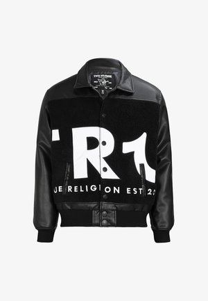 Schwarz-weiße True Religion Jacke mit Ledärmeln, Knopfleiste vorne und großem, fettem Logotext über Brust und Oberkörper.