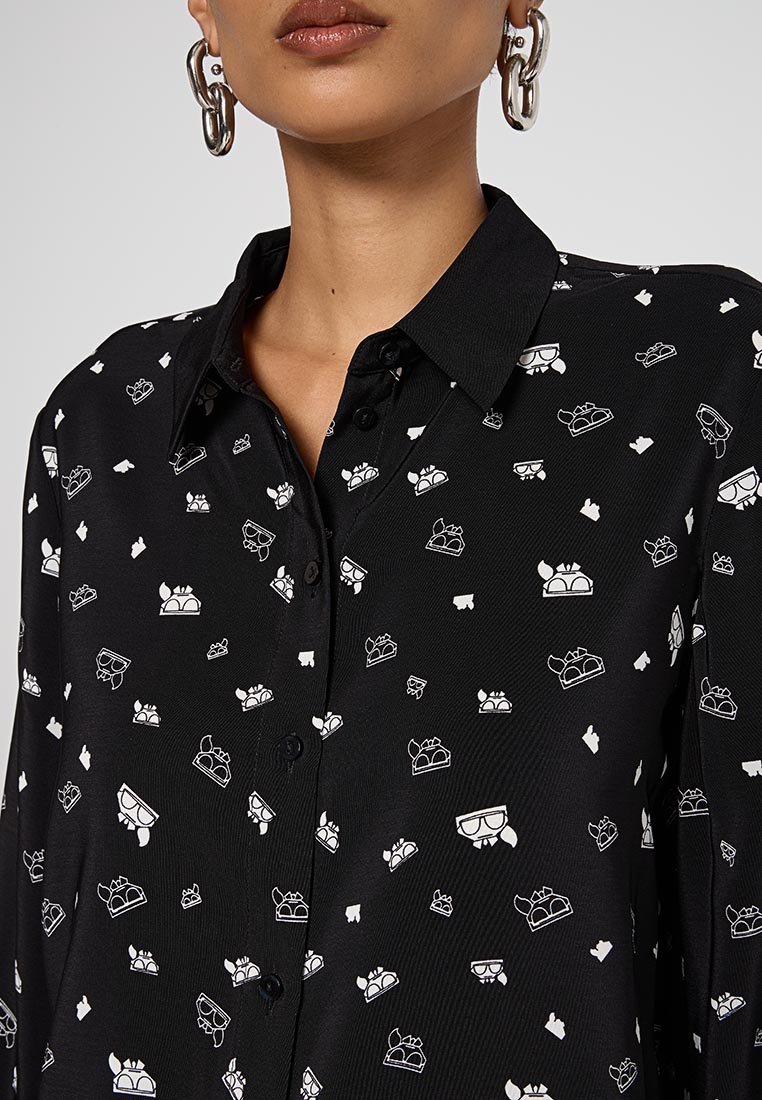 Camisa negra de botones con una textura sutil que presenta patrones repetidos en blanco de coronas y copas. Con cuello y un ajuste clásico.