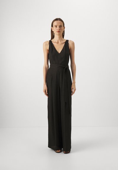 Svart jumpsuit med dyp V-hals, vide ben og belted midje. Glatt tekstur og minimalistisk design med subtile detaljer.