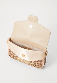 Sac en cuir synthétique beige avec une section inférieure texturée et décorée de pierres. Fermeture à snap, intérieur doublé et logo visible.