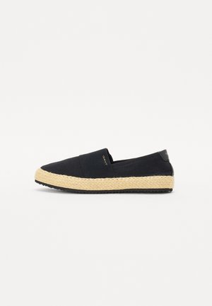 Canvas slip-on shoe in navy blue with a jute rope sole. Features elastic side panels and a black accent at the heel. Flat sole design.