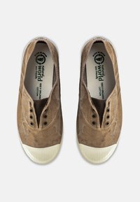 Sneaker in cotone organico marrone con aperture elastiche, cinque fori per i lacci e punta in gomma leggera texturizzata di colore chiaro. Design ecologico.