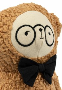 Urs maro din pluș cu textură crețată, față crem, ochi brodați și papion negru. Ursul are o formă rotunjită și un material moale.