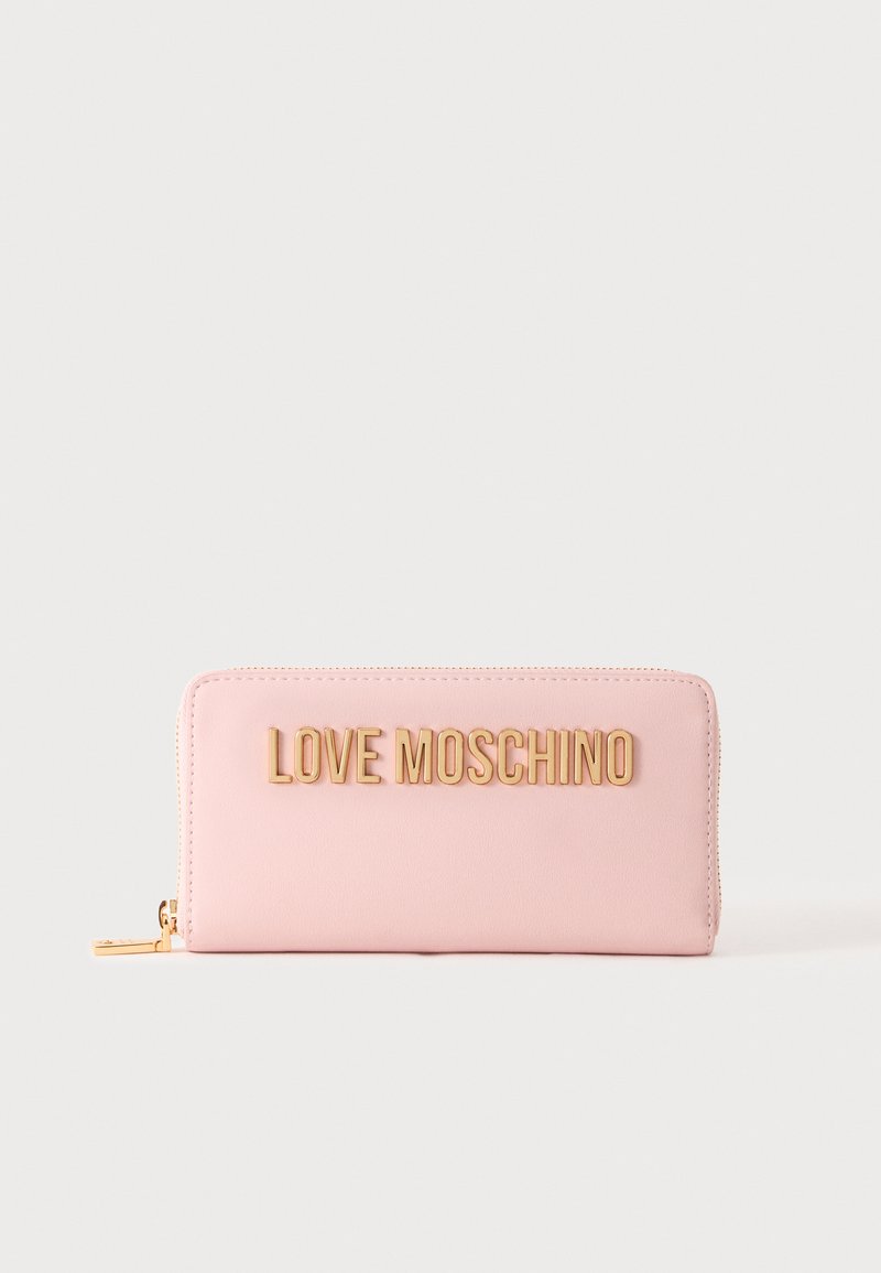 Ροζ ανοιχτή πορτοφόλι με χρυσά γράμματα "LOVE MOSCHINO" και χρυσό τράβηγμα φερμουάρ σε απλό λευκό φόντο.