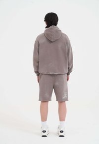 Grau Mischung Baumwoll-Hoodie mit Kapuze, kombiniert mit passenden Shorts; besitzt einen leicht abgetragenen Look und ein Logodetail auf den Shorts.