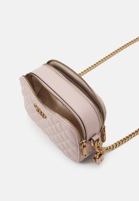 Borsa a tracolla in pelle rosa trapuntata con due scomparti con zip, hardware dorato e tracolla a catena. Superficie testurizzata con accenti.