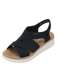 Czarne sandały z krzyżującymi się elastycznymi paskami i odkrytymi palcami, z korkową wkładką i podwyższoną białą gumową podeszwą o teksturowanych brzegach.