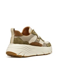 Zapatilla que presenta una combinación de ante y cuero en tonos beige y oliva, con una gruesa entresuela blanca con un patrón ondulado y una suela exterior texturizada en marrón.