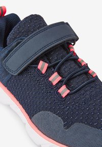 Marineblaue Sneakers mit einem strukturierten Mesh-Obermaterial, rosa und grauen Akzenten, elastischen Schnürsenkeln und einem Klettverschluss. Weiße, gepolsterte Sohlenoption.