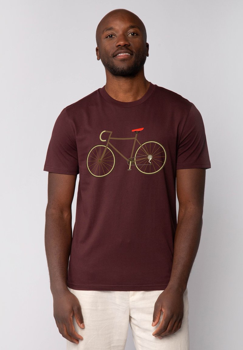 Bordeaux katoenen t-shirt met een fietsafbeelding in aardetinten en een rode zitting. Korte mouwen en een ronde halslijn.