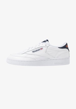 Sneaker in pelle bianca Reebok con chiusura stringata, linguetta sul tallone blu navy e logo Reebok con bandiera britannica sul lato e nella suola intermedia.