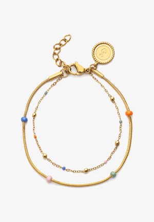 Bracelet à double chaîne dorée avec de petites perles colorées, fermoir mousqueton et pendentif rond portant un symbole gravé.