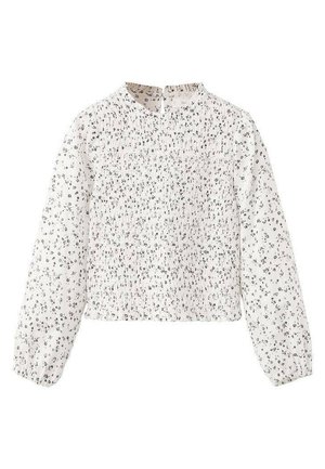 Blouse blanche à manches longues avec petits imprimés floraux noirs, texture froncée au niveau de la poitrine et col montant. Tissu lisse avec poignets élastiques.