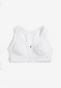 Soutien-gorge de sport blanc avec une fermeture éclair à l'avant, des bretelles larges et un design épuré, en tissu lisse avec un petit logo sur le côté.