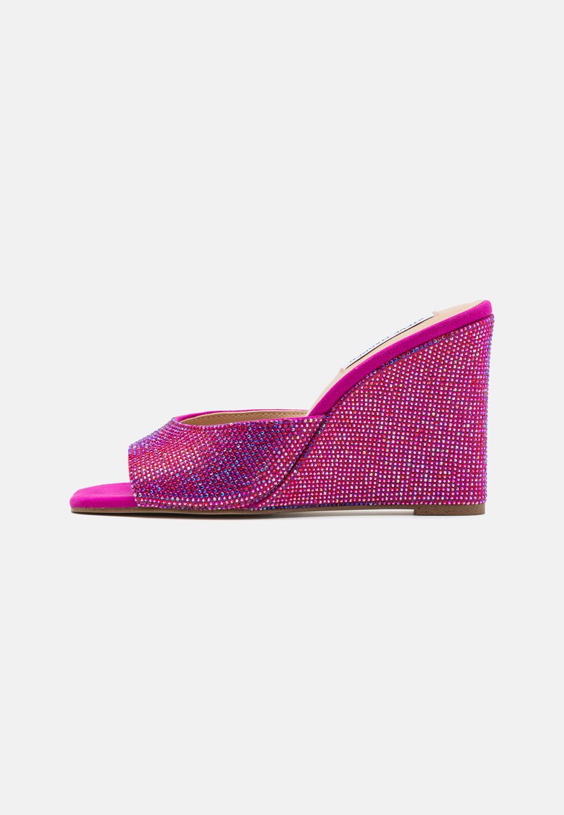 Sandale compensée rose avec une tige texturée recouverte de strass multicolores, ouverte à l'avant et au design courbé. Semelle plate pour une stabilité optimale.