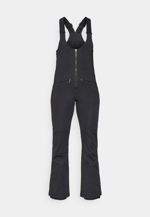 Schwarze Softshell-Latzhose mit verstellbaren Trägern, durchgehendem Reißverschluss, zwei Vorder Taschen und ausgestellten Beinen. Glatte Textur mit taillierter Passform.