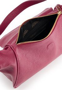 Magenta leather bag with textured surface and gold zip closure. Interior features black fabric lining with logos. Includes adjustable strap.