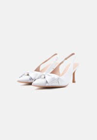 Λευκά πέδιλα από σατέν με λουράκι πίσω, μυτερή μύτη, λεπτομέρεια φιόγκου και διακόσμηση με πέρλα. Τακούνι στιλέτο ύψους 3 ιντσών, μαλακή υφασμάτινη εσωτερική σόλα.