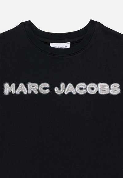 Μαύρο T-shirt με κεντημένο λευκό κείμενο "MARC JACOBS." Στρογγυλή λαιμόκοψη, κοντά μανίκια, απαλό βαμβακερό ύφασ μα, μινιμαλιστικός σχεδιασμός.