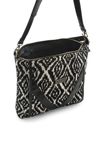 Sac tressé noir et blanc avec des accents en cuir, fermeture zippée et bandoulière ajustable. Il présente une plaque logo en métal doré à l'avant.