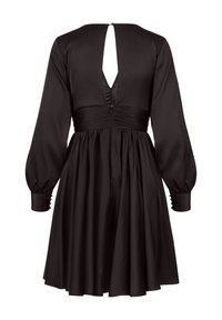 Svart klänning med långa puffärmar, en insvängd midja och en djup V-back. Tillverkad av slät tyg, med en utsvängd kjol och rynkade detaljer.