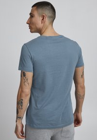 Blå bomulds t-shirt med rund hals, korte ærmer og en afslappet pasform, med en glat tekstur og minimale syninger.
