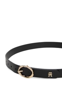 Zwarte leren riem met een goudkleurige ovale gesp en een klein logo-detail. Gladde textuur met meerdere verstelgaten.