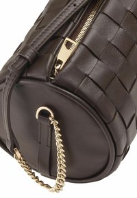Borsa a tracolla in pelle intrecciata marrone, di forma rotonda, con zip dorata e dettagli in catena. Superficie testurizzata con base piatta.
