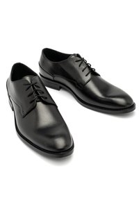 Czarne skórzane buty wizytowe o gładkim wykończeniu, spiczastym nosku i płaskich sznurówkach. Posiadają niski obcas i klasyczny, minimalistyczny design.