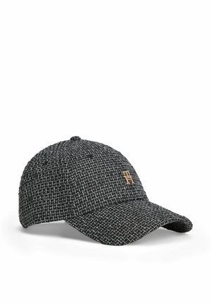 Sort og hvid tekstureret kasket med buet skygge og et lille gyldent emblem på frontpanelet.