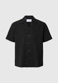 Chemise noire à manches courtes avec un motif ondulé texturé, fermeture à boutons et col classique. Fabriquée en tissu doux et léger.