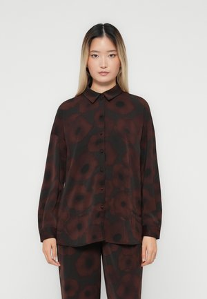 Long-sleeve collared shirt in dark brown fabric with red flower pattern, featuring button closure and a relaxed fit. Smooth, slightly glossy texture.