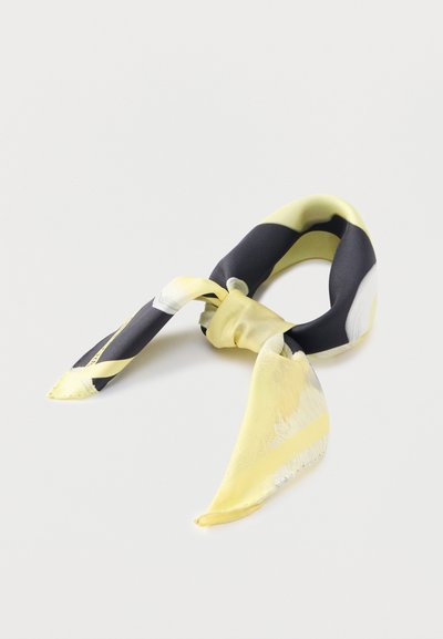 Esarfă de mătase cu un model geometric galben și negru. Prezintă o textură netedă și capete ascuțite. Legată într-un nod pentru expunere.