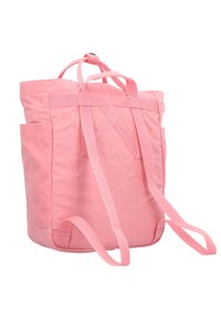 Vaaleanpunainen kangaskaukalovara, jossa on säädettävät hihnat, etutasku ja minimalistinen muotoilu, jossa on ristiin menevät hihnat ylhäällä.