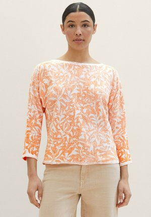 Haut à manches longues à motif floral orange et blanc avec un col bateau et une coupe décontractée, fabriqué en tissu léger.