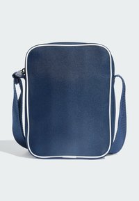 Kobaltno plava torbica na rame pravokutnog oblika, teksturirane tkanine, bijelih obruba i pletenog remena. Ima gornji zatvarač na patentni zatvarač.