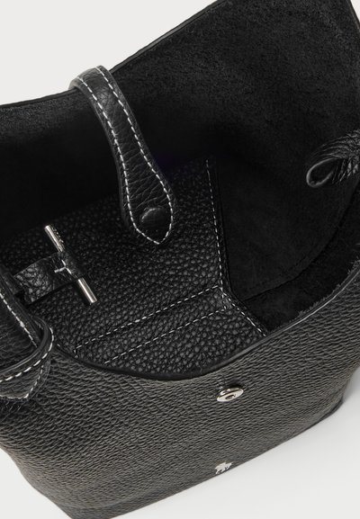 Μαύρη δερμάτινη τσάντα με υφή, λεία επιφάνεια και ασημί αξεσουάρ. Ο εσωτερικός χώρος διαθέτει σουέτ επένδυση και ασφαλή μηχανισμό κλεισίματος.