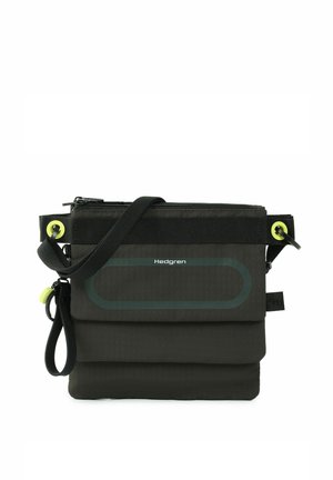 Petit sac bandoulière noir Hedgren compact avec sangle réglable, fermeture éclair sur le dessus, rabat avant et œillets jaunes en accent.