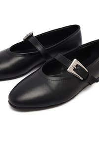 Zwarte leren balletschoenen met een spitse neus, voorzien van een dunne band over de voet en een metalen gespdetail. Gladde textuur.